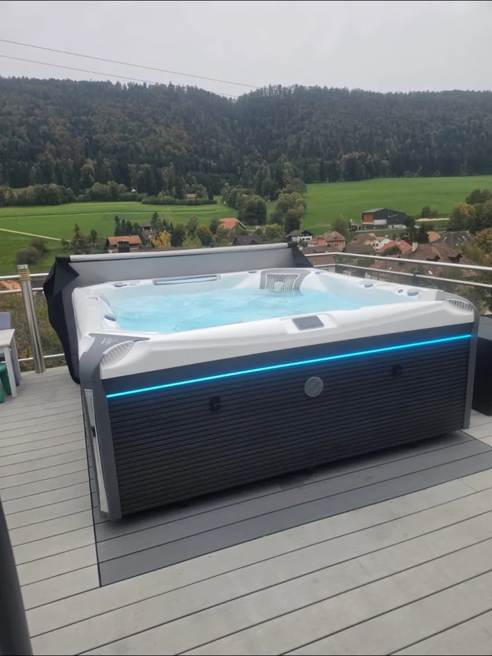 Idromassaggio scuro con LED blu su terrazza affacciata sulla campagna