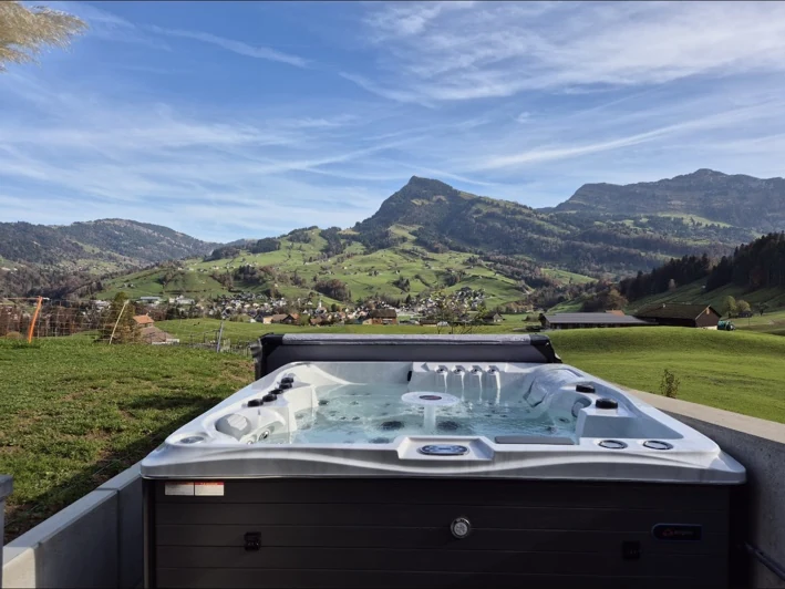 Idromassaggio davanti a un prato e a un panorama montano