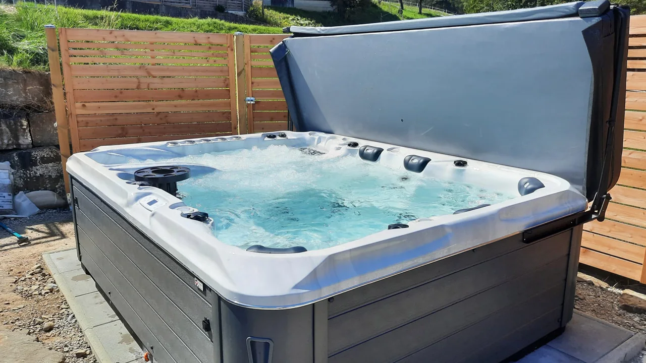 Idromassaggio – Su una terrazza in legno davanti a una schermatura in legno.